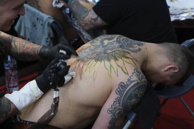 Brüksel, Belçika. 9 Kasım 2019. Uluslararası Brüksel Dövme Kongresi sırasında bir dövme sanatçısı bir kişiye dövme yaptırdı.