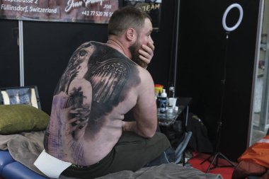 Brüksel, Belçika. 9 Kasım 2019. Uluslararası Brüksel Dövme Kongresi sırasında bir dövme sanatçısı bir kişiye dövme yaptırdı.