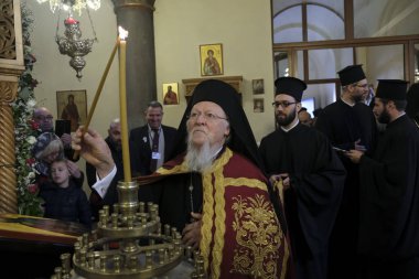 Ekümenik Patrik 1. Bartholomew, 10 Kasım 2019 'da Belçika' nın Brüksel kentindeki Aziz Başmelekleri Michael ve Gabriel Ortodoks Katedrali 'ndeki ayine katılmak üzere geldiğinde bir mum yakar..