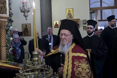 Ekümenik Patrik 1. Bartholomew, 10 Kasım 2019 'da Belçika' nın Brüksel kentindeki Aziz Başmelekleri Michael ve Gabriel Ortodoks Katedrali 'ndeki ayine katılmak üzere geldiğinde bir mum yakar..