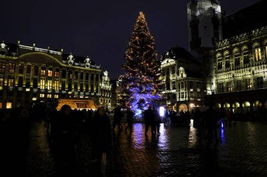 Grand Place 'de ışıklar ve 2 Aralık 2019' da Belçika, Brüksel 'deki kutlama atmosferinin tadını çıkaran bir kalabalık ile birlikte büyük bir Noel ağacı sergileniyor..
