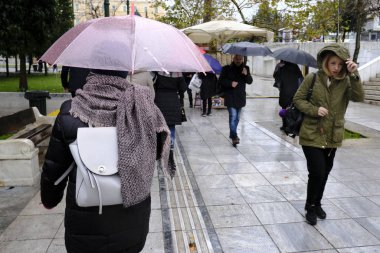 Yunanistan 'ın başkenti Atina' da 30 Aralık 2019 'da meydana gelen yağış sırasında yayalar kendilerini şemsiyelerle yağmurdan koruyorlar..