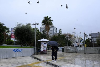 Yunanistan 'ın başkenti Atina' da 30 Aralık 2019 'da meydana gelen yağış sırasında yayalar kendilerini şemsiyelerle yağmurdan koruyorlar.