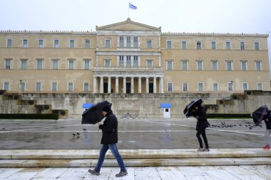 Yunanistan 'ın başkenti Atina' da 30 Aralık 2019 'da meydana gelen yağış sırasında yayalar kendilerini şemsiyelerle yağmurdan koruyorlar.
