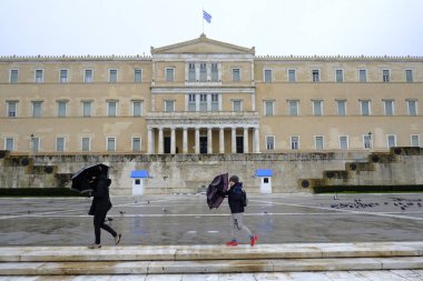 Yunanistan 'ın başkenti Atina' da 30 Aralık 2019 'da meydana gelen yağış sırasında yayalar kendilerini şemsiyelerle yağmurdan koruyorlar.