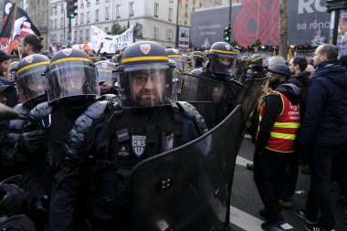 Fransız isyan polisi 17 Aralık 2019 'da Paris, Fransa' da emeklilik reformlarına karşı düzenlenen gösteride bölgeyi emniyete aldı..