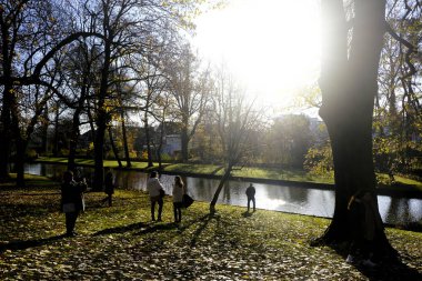 İnsanlar Belçika 'nın Bruges Kanalı' nın güneşli gününün tadını çıkarıyorlar. 30 Kasım 2019.