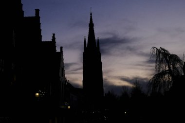 30 Kasım 2019 'da Belçika' da ağaç siluetleri ve Bruges çan kulesi.