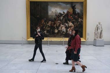 Ziyaretçiler, 19 Mayıs 2020 'de Belçika' nın Brüksel kentindeki Kraliyet Güzel Sanatlar Müzesi 'ndeki resimlere bakarken koronavirüsün yayılmasını önlemek için yüz maskesi takıyorlar..