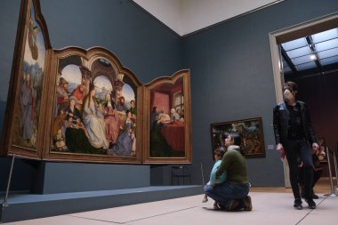 Ziyaretçiler, 19 Mayıs 2020 'de Belçika' nın Brüksel kentindeki Kraliyet Güzel Sanatlar Müzesi 'ndeki resimlere bakarken koronavirüsün yayılmasını önlemek için yüz maskesi takıyorlar..