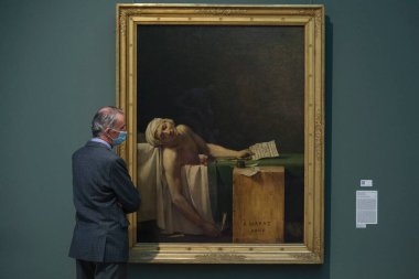 Ziyaretçiler, 19 Mayıs 2020 'de Belçika' nın Brüksel kentindeki Kraliyet Güzel Sanatlar Müzesi 'ndeki resimlere bakarken koronavirüsün yayılmasını önlemek için yüz maskesi takıyorlar..