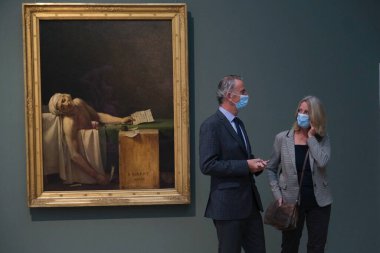 Ziyaretçiler, 19 Mayıs 2020 'de Belçika' nın Brüksel kentindeki Kraliyet Güzel Sanatlar Müzesi 'ndeki resimlere bakarken koronavirüsün yayılmasını önlemek için yüz maskesi takıyorlar..