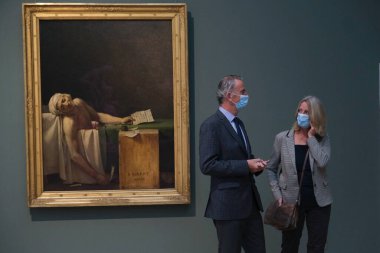 Visitors wear face masks, to prevent the spread of coronavirus, as they look at paintings at the Royal Museum of Fine Arts in Brussels, Belgium on May 19, 2020. clipart