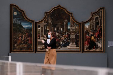 Ziyaretçiler, 19 Mayıs 2020 'de Belçika' nın Brüksel kentindeki Kraliyet Güzel Sanatlar Müzesi 'ndeki resimlere bakarken koronavirüsün yayılmasını önlemek için yüz maskesi takıyorlar..