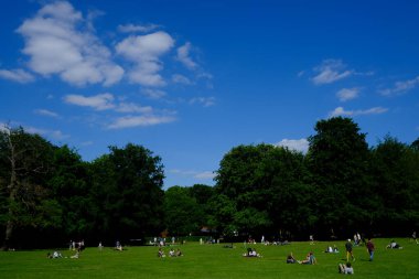 İnsanlar 17 Mayıs 2020 'de Brüksel, Belçika' daki Bois de la Cambre kentsel parkında güneşin keyfini çıkarıyorlar..