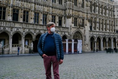 Belçika 3 Mayıs 2020 'de Brüksel, Belçika' da koronavirüs hastalığının yayılmasını yavaşlatmak için şehir merkezinde yürüyen koruyucu maskeli bir yaya görülüyor.