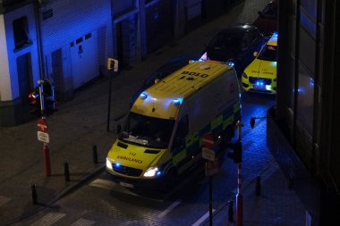 Korunma ekipmanı takan ilk yardım itfaiyecileri, 5 Mayıs 2020 'de Belçika' da Brüksel 'deki bir hastaneye ambulansla götürülmeden önce COVID-19 taşıdığından şüphelenilen bir hastayı taşıyorlar..