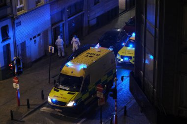 Korunma ekipmanı takan ilk yardım itfaiyecileri, 5 Mayıs 2020 'de Belçika' da Brüksel 'deki bir hastaneye ambulansla götürülmeden önce COVID-19 taşıdığından şüphelenilen bir hastayı taşıyorlar..