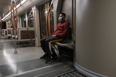 Brüksel, Belçika 'da 6 Mayıs 2020' de meydana gelen koronavirüs salgını sonrasında metroda koruyucu yüz maskesi takan bir yolcu..