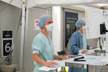 5 Mayıs 2020 'de Belçika' da, Liege Üniversite Hastanesi 'nin triyajında Coronavirus belirtileri gösteren çok az hasta ile tıbbi personel çalışmaktadır..