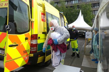 Belçika 'daki Liege Üniversitesi Hastanesi' ne 5 Mayıs 2020 'de COVID-19 semptomlarının tedavisi için ambulansla gelen bir hasta görülüyor..