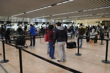 Koronavirüsün yayılmasını önlemek için ağız maskesi takan yolcular, 15 Mayıs 2020 'de Brüksel' deki Brüksel Uluslararası Havalimanı 'nda Atina' ya giriş için sırada beklesinler..