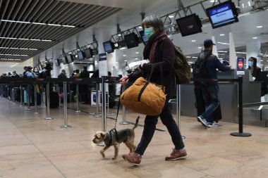 Koronavirüsün yayılmasını önlemek için ağız maskesi takan yolcular, 15 Mayıs 2020 'de Brüksel' deki Brüksel Uluslararası Havalimanı 'nda Atina' ya giriş için sırada beklesinler..