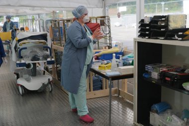 5 Mayıs 2020 'de Belçika' daki Liege Üniversitesi Hastanesi 'nde COVID-19 hastalarına yardım etmeden önce bir sağlık çalışanı kişisel koruyucu ekipman (PPE) giyer.