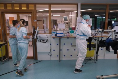 5 Mayıs 2020 'de Belçika' daki Liege Üniversitesi Hastanesi 'nde COVID-19 hastalarına yardım etmeden önce bir sağlık çalışanı kişisel koruyucu ekipman (PPE) giyer.