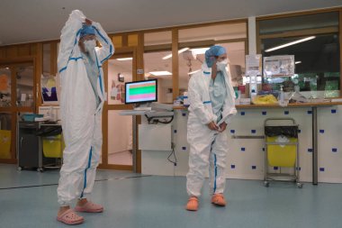 5 Mayıs 2020 'de Belçika' daki Liege Üniversitesi Hastanesi 'nde COVID-19 hastalarına yardım etmeden önce bir sağlık çalışanı kişisel koruyucu ekipman (PPE) giyer.