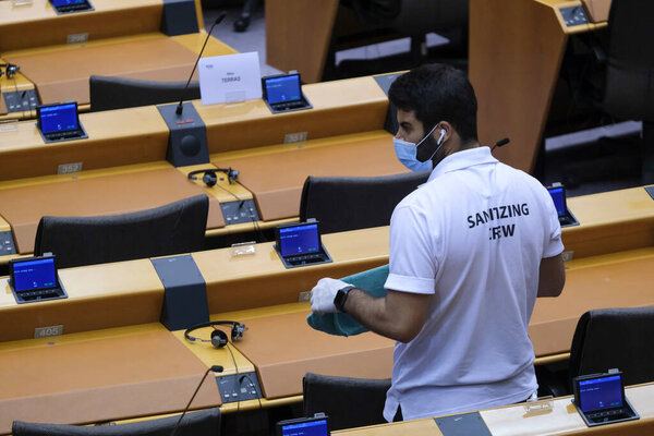 Members of a sanitising crew clean the hemicycle ahead to plenary session of the European Parliament in Brussels, Belgium on May 13, 2020.