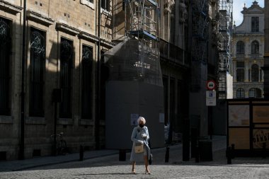 Koruyucu yüz maskesi takan bir yaya 12 Mayıs 2020 'de Brüksel, Belçika' da yürüyor.