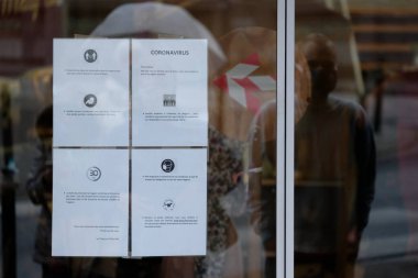 Müşteriler, Belçika 'nın Brüksel kentinde 4 Mayıs 2020' de bir tuhafiyecinin önünde kuyruğa girerken 