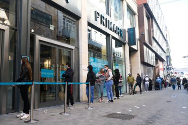 Müşteriler 11 Mayıs 2020 'de Brüksel, Belçika' nın ana ticari caddesi Neuve sokağındaki dükkanlara girmek için kuyruğa girdiler. Yetkililer, 11 Mayıs itibarıyla gereksiz mağazaların kapılarını müşterilere açmasına izin verdiler.. 