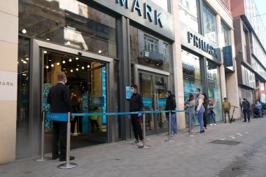 Müşteriler 11 Mayıs 2020 'de Brüksel, Belçika' nın ana ticari caddesi Neuve sokağındaki dükkanlara girmek için kuyruğa girdiler. Yetkililer, 11 Mayıs itibarıyla gereksiz mağazaların kapılarını müşterilere açmasına izin verdiler.. 