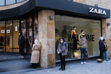 Müşteriler 11 Mayıs 2020 'de Brüksel, Belçika' nın ana ticari caddesi Neuve sokağındaki dükkanlara girmek için kuyruğa girdiler. Yetkililer, 11 Mayıs itibarıyla gereksiz mağazaların kapılarını müşterilere açmasına izin verdiler.. 