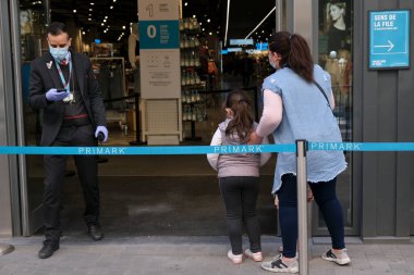 Müşteriler 11 Mayıs 2020 'de Brüksel, Belçika' nın ana ticari caddesi Neuve sokağındaki dükkanlara girmek için kuyruğa girdiler. Yetkililer, 11 Mayıs itibarıyla gereksiz mağazaların kapılarını müşterilere açmasına izin verdiler.. 