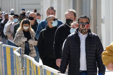 Müşteriler 11 Mayıs 2020 'de Brüksel, Belçika' nın ana ticari caddesi Neuve sokağındaki dükkanlara girmek için kuyruğa girdiler. Yetkililer, 11 Mayıs itibarıyla gereksiz mağazaların kapılarını müşterilere açmasına izin verdiler.. 