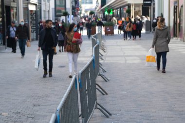 Yüz maskesi takan insanlar, 11 Mayıs 2020 Pazartesi günü Brüksel 'de koronavirüsün, COVID-19' un yayılmasını önlemek için, tecrit sürecinin kademeli kaldırılması sırasında ticari caddede yürürler..