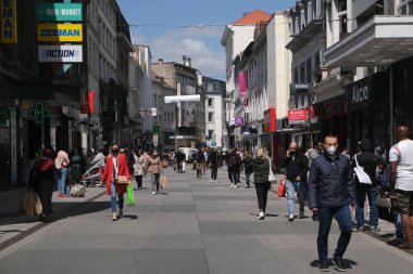 Yüz maskesi takan insanlar, 11 Mayıs 2020 Pazartesi günü Brüksel 'de koronavirüsün, COVID-19' un yayılmasını önlemek için, tecrit sürecinin kademeli kaldırılması sırasında ticari caddede yürürler..