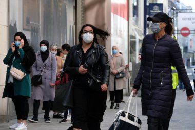 Yüz maskesi takan insanlar, 11 Mayıs 2020 Pazartesi günü Brüksel 'de koronavirüsün, COVID-19' un yayılmasını önlemek için, tecrit sürecinin kademeli kaldırılması sırasında ticari caddede yürürler..
