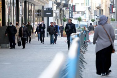 Yüz maskesi takan insanlar, 11 Mayıs 2020 Pazartesi günü Brüksel 'de koronavirüsün, COVID-19' un yayılmasını önlemek için, tecrit sürecinin kademeli kaldırılması sırasında ticari caddede yürürler..