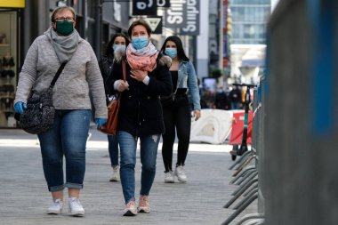 Yüz maskesi takan insanlar, 11 Mayıs 2020 Pazartesi günü Brüksel 'de koronavirüsün, COVID-19' un yayılmasını önlemek için, tecrit sürecinin kademeli kaldırılması sırasında ticari caddede yürürler..
