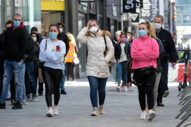 Yüz maskesi takan insanlar, 11 Mayıs 2020 Pazartesi günü Brüksel 'de koronavirüsün, COVID-19' un yayılmasını önlemek için, tecrit sürecinin kademeli kaldırılması sırasında ticari caddede yürürler..