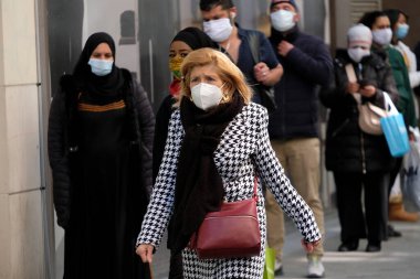 Yüz maskesi takan insanlar, 11 Mayıs 2020 Pazartesi günü Brüksel 'de koronavirüsün, COVID-19' un yayılmasını önlemek için, tecrit sürecinin kademeli kaldırılması sırasında ticari caddede yürürler..