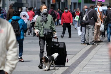 Yüz maskesi takan insanlar, 11 Mayıs 2020 Pazartesi günü Brüksel 'de koronavirüsün, COVID-19' un yayılmasını önlemek için, tecrit sürecinin kademeli kaldırılması sırasında ticari caddede yürürler..