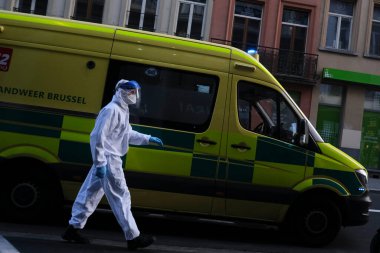 16 Mayıs 2020 'de Brüksel, Belçika' da COVID-19 ile enfekte olduğundan şüphelenilen, kişisel koruma ekipmanı (PPE) taşıyan bir itfaiyeci bir hastayı sedyeyle boşalttı.