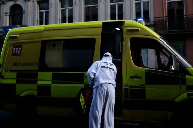 16 Mayıs 2020 'de Brüksel, Belçika' da COVID-19 ile enfekte olduğundan şüphelenilen, kişisel koruma ekipmanı (PPE) taşıyan bir itfaiyeci bir hastayı sedyeyle boşalttı.