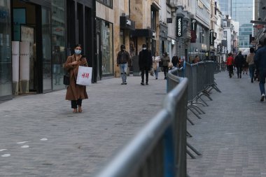 Yüz maskesi takan insanlar, 12 Mayıs 2020 Pazartesi günü Brüksel 'de koronavirüsün, COVID-19' un yayılmasını önlemek için, tecrit sürecinin kademeli kaldırılması sırasında ticari caddede yürürler..