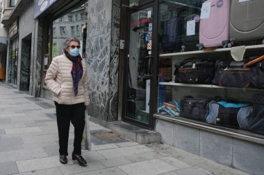Yüz maskesi takan insanlar, 12 Mayıs 2020 Pazartesi günü Brüksel 'de koronavirüsün, COVID-19' un yayılmasını önlemek için, tecrit sürecinin kademeli kaldırılması sırasında ticari caddede yürürler..